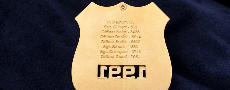 Henry County fallen officers on the back of a metal police badge as a memorial