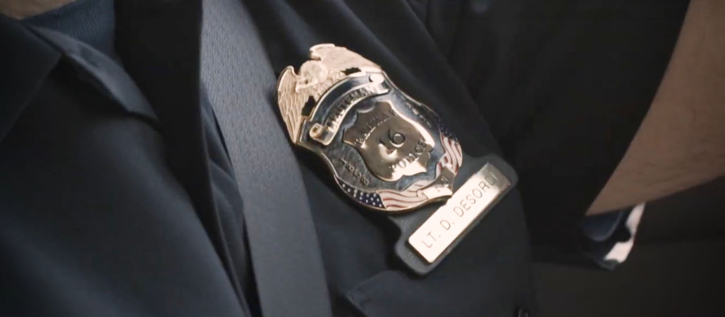 close up of a seat belt next to a police badge 