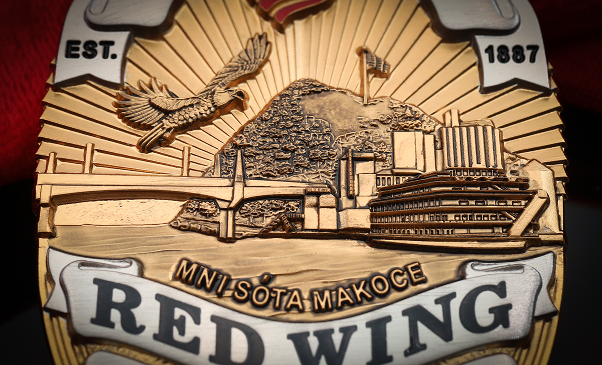 Close-up of the finished Red Wing Police custom badge showing a bald eagle, He Mni Can–Barn Bluff, the Mississippi River, bridge, riverboat, and “Mni Sóta Makoce” lettering.