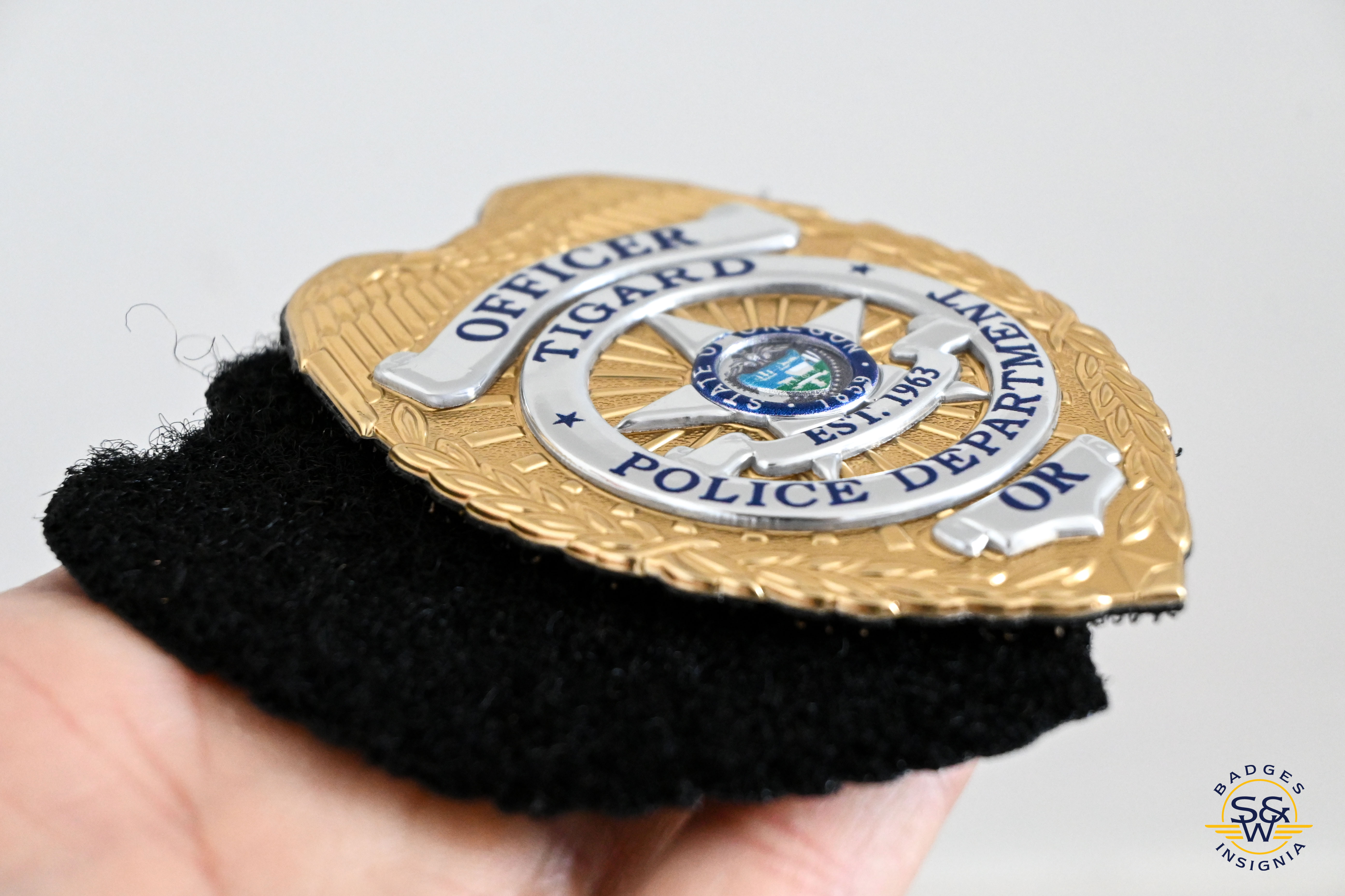 A Flexbadge being held showing detail and hook and loop backing.