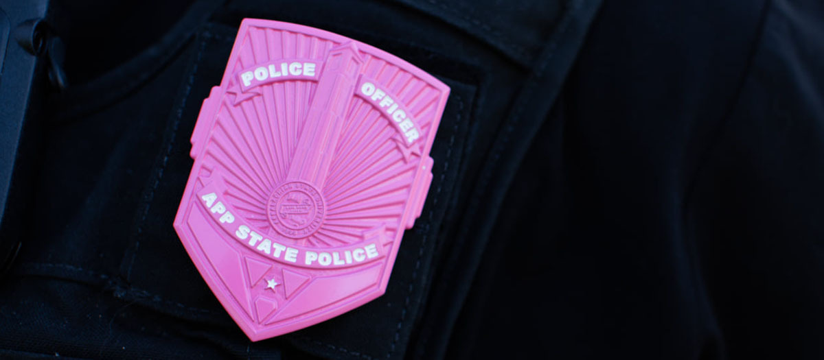A close up of a pink awareness badge on law enforcement uniform.
