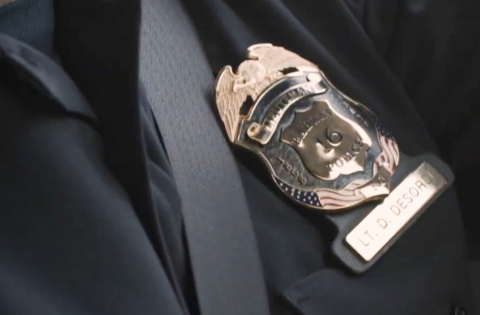 close up of a seat belt next to a police badge 