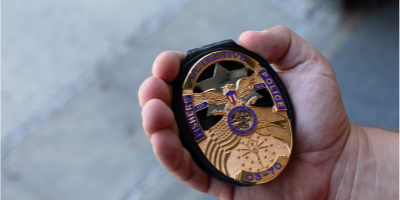 Badge held by police officer carefully